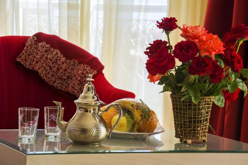 
a table topped with a vase filled with flowers at Hôtel Racine in Marrakesh
