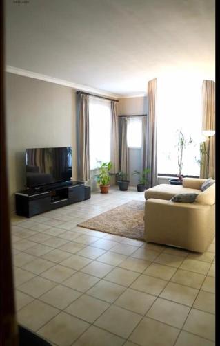 a living room with a couch and a flat screen tv at Beautiful 4 bedroom Villa close to Antwerp in Zwijndrecht