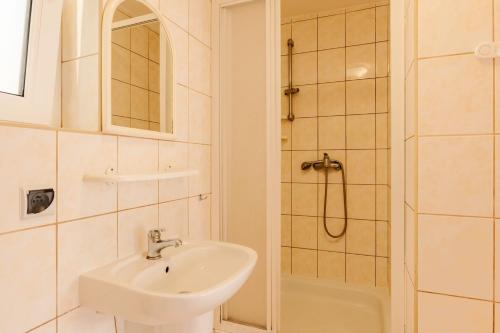 a bathroom with a sink and a shower at Dom gościnny Słoneczny Zakątek in Dziwnówek
