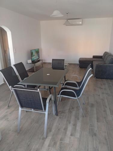 a living room with a table and chairs and a couch at Nea Vrasna Sun House in Nea Vrasna