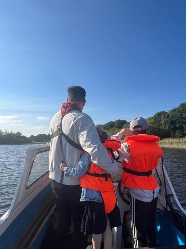 a man and two children in a boat on the water at Rose Glamping pod in Derrylin
