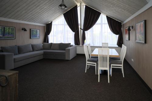 a living room with a couch and a table and chairs at VILSON hotel in Bukovel