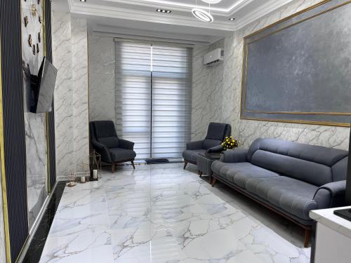 a living room with a couch and two chairs at Delmar resıdence in Mekhrably