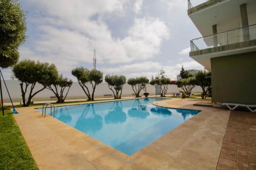 a swimming pool in front of a building at Magnifique studio cosy et lumineux avec vue sur mer in Tamaris