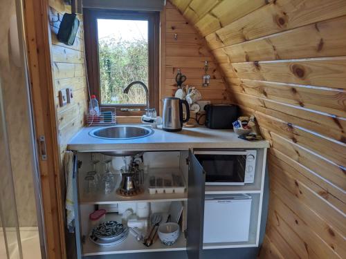 a kitchen in a tiny house with a sink at Rose Glamping pod in Derrylin