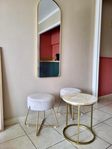 une chambre avec deux chaises et un miroir dans l'établissement Cannes Eden By SCLS Locations, à Cannes