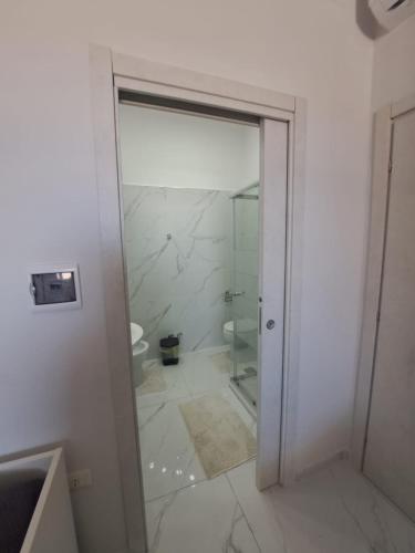 a bathroom with a glass shower and a toilet at Le follie in Maddaloni