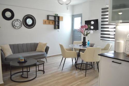 Una cocina y una sala de estar con mesa y sillas. en Helen Apartment, en Ermoupoli