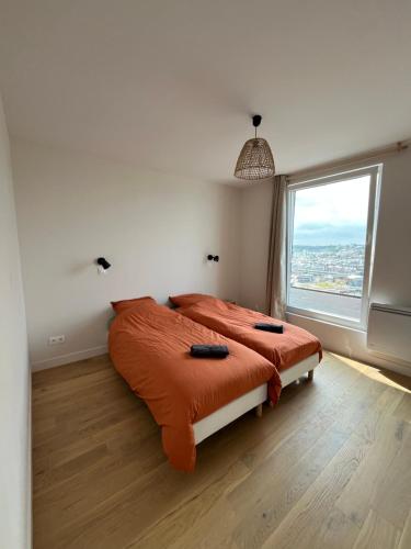 - une chambre avec un lit doté d'une couette en orange et d'une fenêtre dans l'établissement Villa with panoramic sea view, à Fécamp
