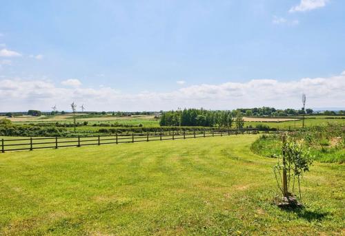 a fence in a field with green grass at Carnbore House BnB in Bushmills