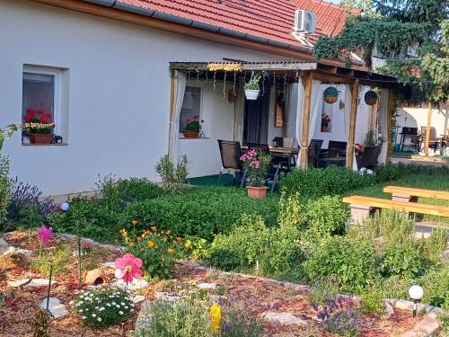 a garden in front of a house with a bench at Százszorszép Vendégház in Csongrád