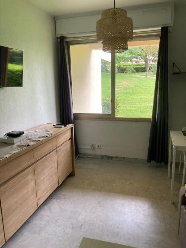 - un salon avec une grande fenêtre et un bureau dans l'établissement A 5 minutes du centre de Juan les pins et de la mer ! Appartement dans résidence avec piscine et terrain de tennis, à Antibes