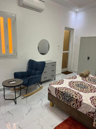a bedroom with a bed and a chair and a table at ABK Apparts in Rufisque