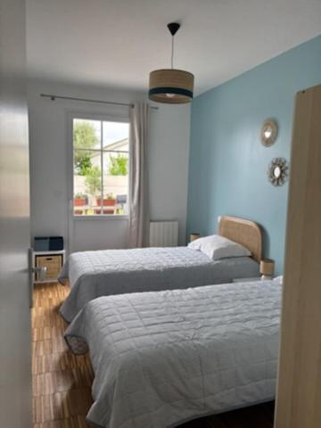 une chambre avec deux lits et une fenêtre dans l'établissement Tal Ar Mor, à Plougasnou