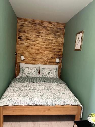 a bedroom with a bed with a wooden headboard at Apartmán Na Dukelské s garáží in Tábor