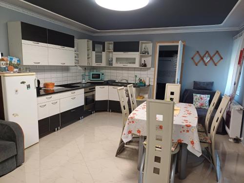 a kitchen and dining room with a table and refrigerator at Százszorszép Vendégház in Csongrád