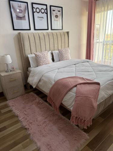 a bedroom with a large bed with a pink rug at Kiambu Best Home in Nairobi