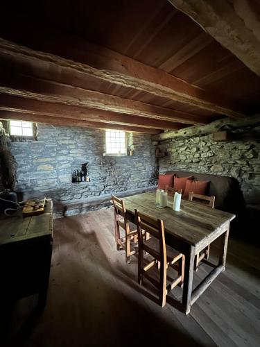 Cette chambre dispose d'une table et de chaises en bois. dans l'établissement La bayta de mon père, à Réotier