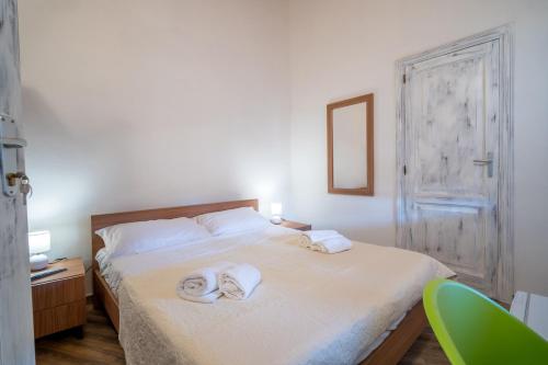 a bedroom with a bed with towels on it at Casa Boyl Rooms in Putifigari
