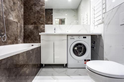 a bathroom with a washing machine and a sink at Сучасні апартаменти в новобудові in Lviv