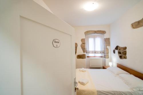 a bedroom with a bed and a window at Casa Boyl Rooms in Putifigari