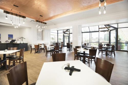 a dining room with tables and chairs and windows at Fort Pontchartrain Detroit, a Wyndham Hotel in Detroit