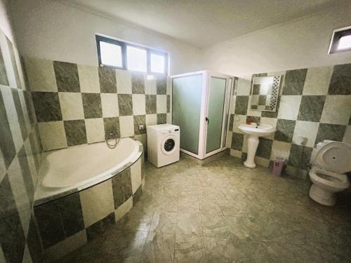a bathroom with a tub and a toilet and a sink at Vacation House with Private Pool in Baie du Tombeau