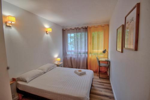 une petite chambre avec un lit et une fenêtre dans l'établissement Suite T6 Rennes - Idéal Entreprises & Familles, à Rennes