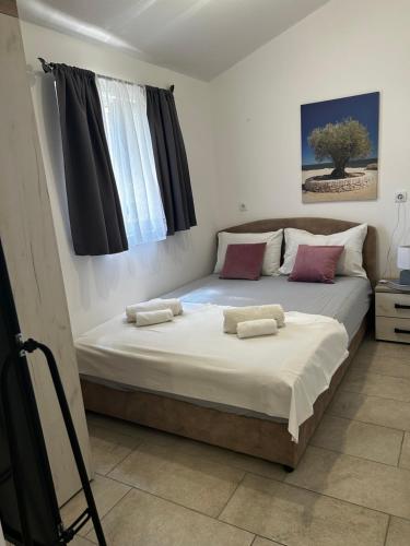 a bedroom with a large bed with two pillows on it at Fisherman's House Gušti in Kamenari