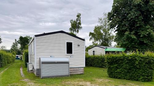 a small white tiny house in a yard at wallerseehomes 110 in Baierham