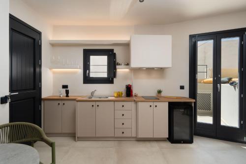 a kitchen with white cabinets and a sink at White Orchid Boutique Apartments in Vóthon