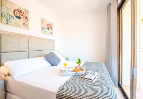 a bed with a tray of fruit on it at Ona Aquamarina in La Pineda