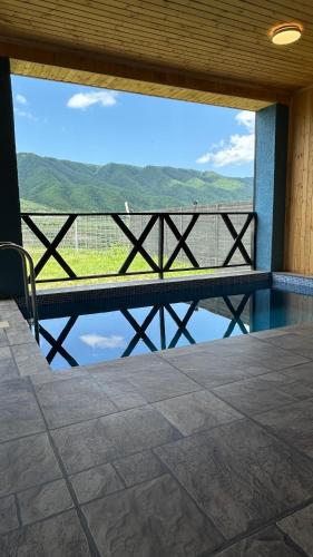 a balcony with a view of the water and mountains at Shahdag Berghoff House in Qusar