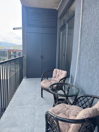 a balcony with two chairs and a glass table at Fatmanis 98 in Tbilisi City