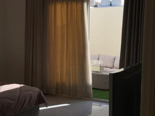 ein Schlafzimmer mit einem Bett und einem Fenster mit einer Couch in der Unterkunft Irm Studio in Quai