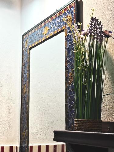 a mirror on a wall with a vase of flowers at La Casa dei Carrai in Pitigliano