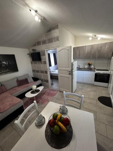 a living room with a table with a bowl of fruit on it at Fisherman's House Gušti in Kamenari