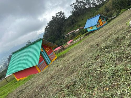 a group of colorful houses on a hill at Glamping Bugambilia in Subía
