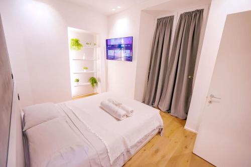 a white room with a bed with towels on it at Central-Luxury Free Wi-Fi, AC in Genova