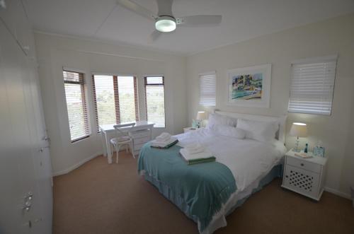 a bedroom with a bed and a table and chairs at The Mermaid's Tail in Pringle Bay