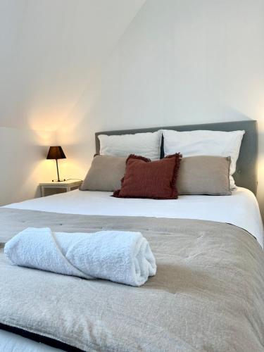 - un lit blanc avec une serviette dans l'établissement Échappée Belle du Mont-Saint-Michel, à Saint-Georges-de-Gréhaigne