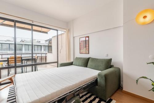 a bedroom with a bed and a large window at Gallarija Caparica in Costa da Caparica