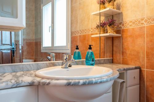 a bathroom with a sink and two bottles on a counter at Casa Saona En Riumar ( a 100m de la playa ) in Riumar