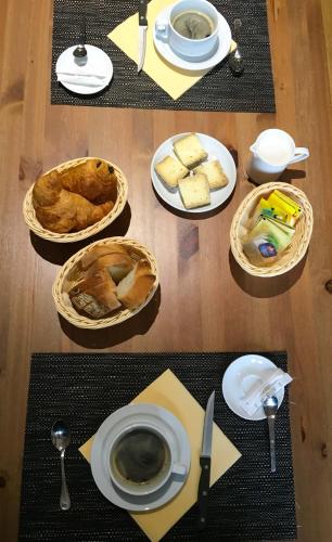 a table with plates of bread and a cup of coffee at Gites Le Lancelot in Ambierle