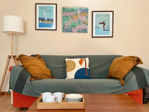 a living room with a green couch with pillows and a table at BELLE ILE PARK in Griante Cadenabbia