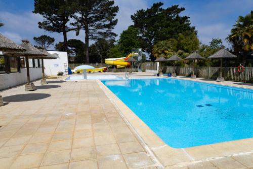 - une piscine dans un complexe avec toboggan dans l'établissement Mobil-home convivial avec vue sur mer - Pleubian, à Pleubian