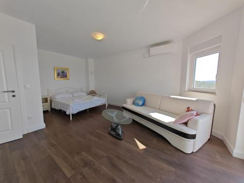 a living room with a couch and a bed at Vila Kathy - kuća za odmor in Seget Vranjica