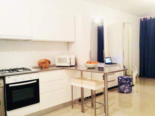 a kitchen with white cabinets and a counter with a microwave at Northern Cyprus, Trikomo, Iskele, Long Beach, Caesar Resort, 8 in Mağusa