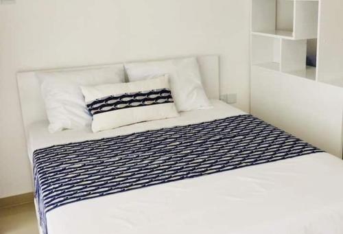 a white bed with black and white sheets and pillows at Northern Cyprus, Trikomo, Iskele, Long Beach, Caesar Resort, 8 in Mağusa