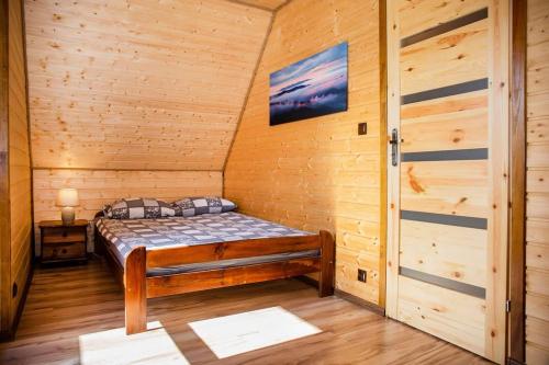 a small room with a bed in a cabin at Sielanka - Domki Całoroczne in Bezmiechowa Dolna